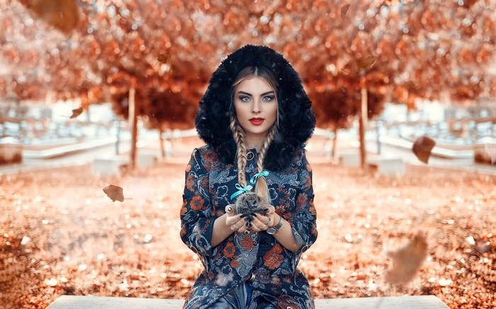 Woman holding a hedgehog in autumn park