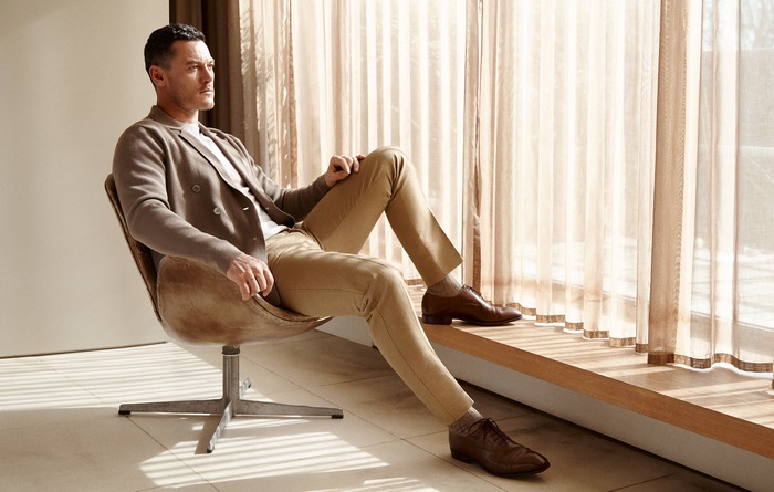 Luke Evans sitting in a chair
