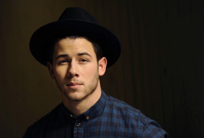 Nick Jonas wearing a hat and blue plaid shirt