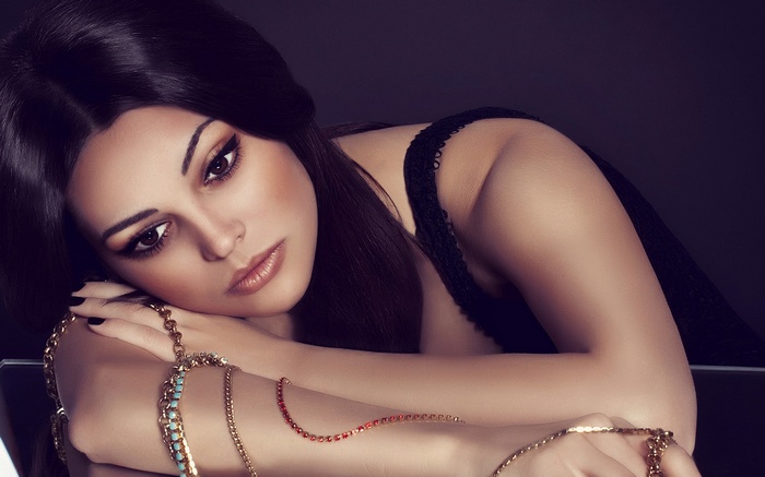 Woman with dark hair and jewelry