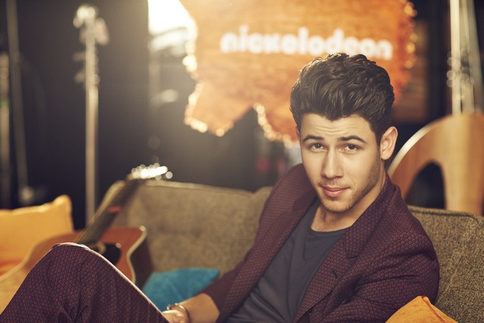 Nick Jonas in front of Nickelodeon logo