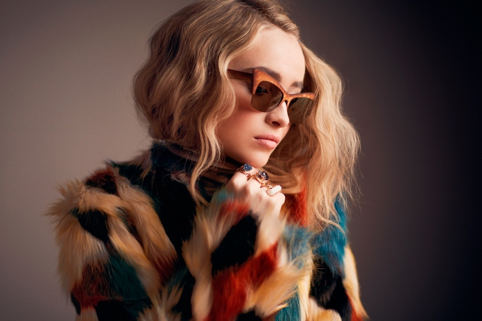 Sabrina Carpenter in a colorful faux fur coat and sunglasses