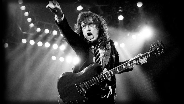Angus Young playing guitar on stage