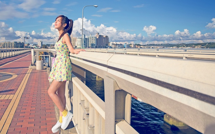 Young woman on a bridge overlooking a city
