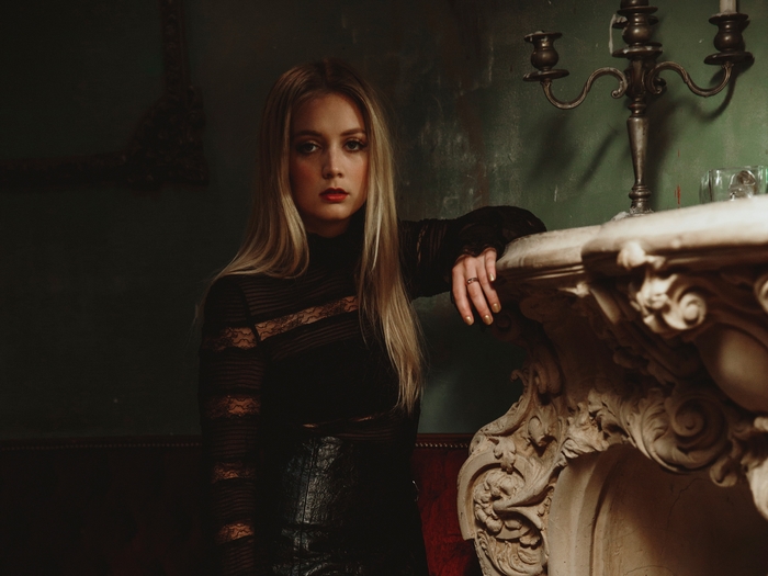 Billie Lourd by a fireplace