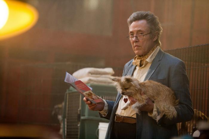 Christopher Walken holding a dog and a pamphlet