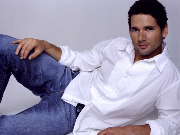 Eric Bana posing in white shirt and jeans