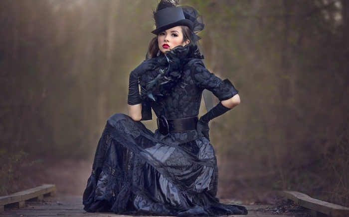 Woman in Victorian-style black dress and top hat
