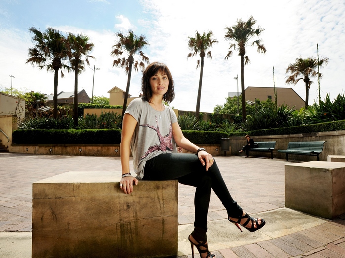 Natalie Imbruglia sitting on a stone bench