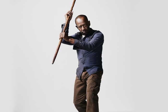 Lennie James holding a wooden staff