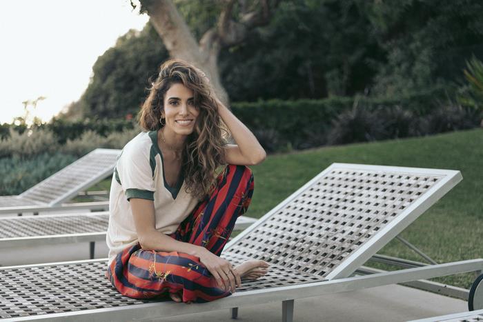 Nikki Reed sitting on a lounge chair
