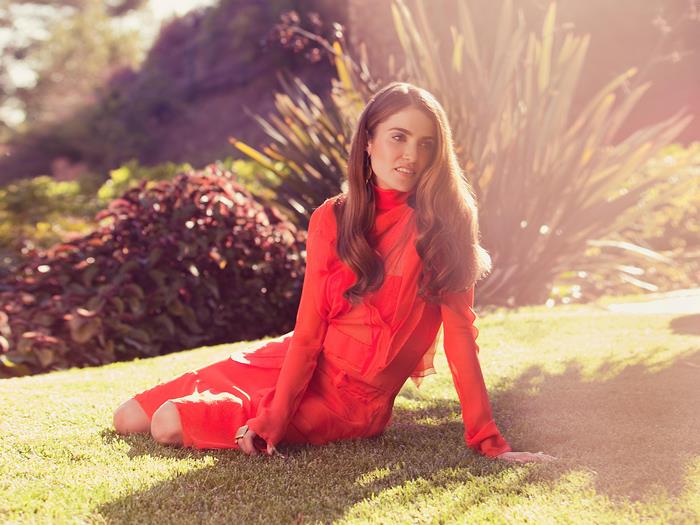 Nikki Reed sitting on grass
