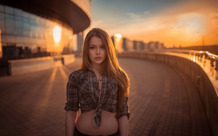 Woman in plaid shirt at sunset