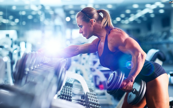 Woman lifting dumbbell in gym