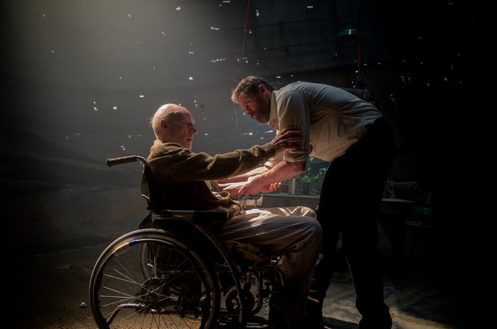 Patrick Stewart in a wheelchair with another man