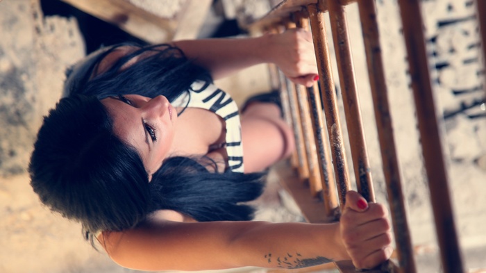 Woman holding onto a rusty railing