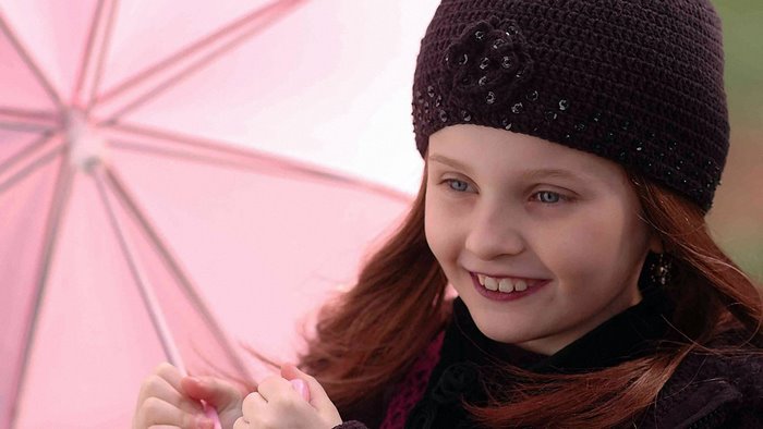 Abigail Breslin holding a pink umbrella