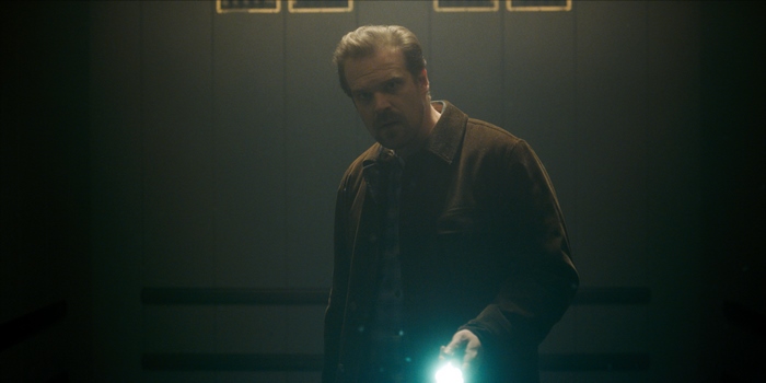 David Harbour holding a flashlight