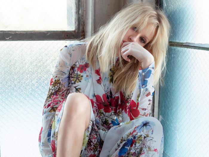Ellie Goulding sitting by a window