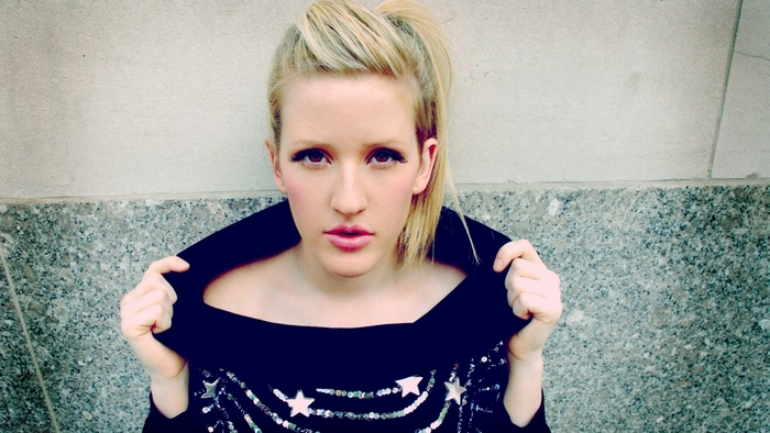 Ellie Goulding posing against a wall