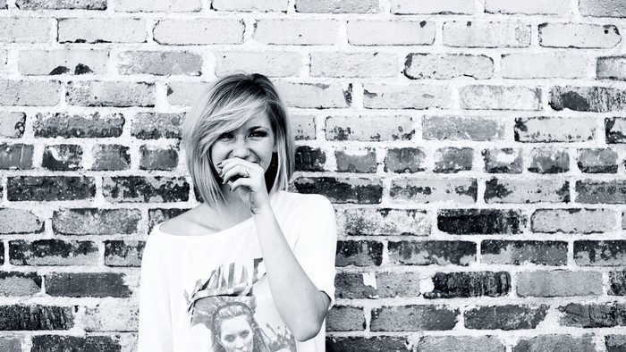Ellie Goulding against a brick wall