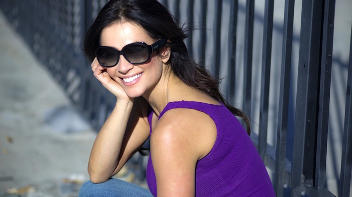 Woman wearing sunglasses and purple tank top