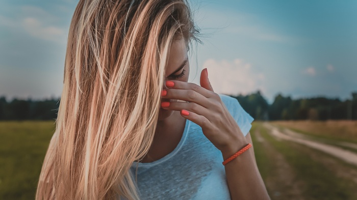 Woman with blonde hair covering her face
