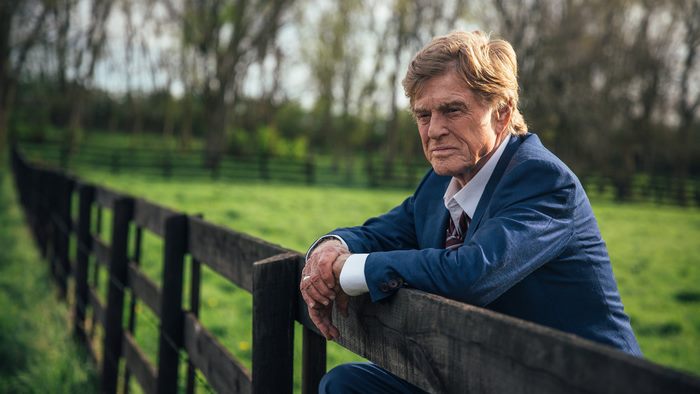 Robert Redford leaning on a fence