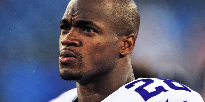 Adrian Peterson wearing a white jersey with purple numbers