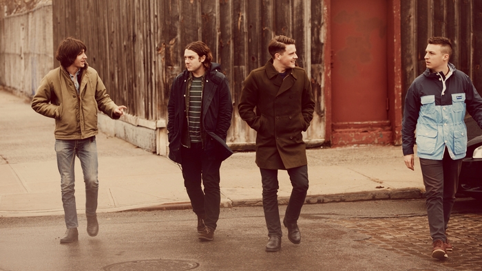 Arctic Monkeys walking down a street