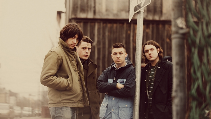 Arctic Monkeys band members standing outdoors