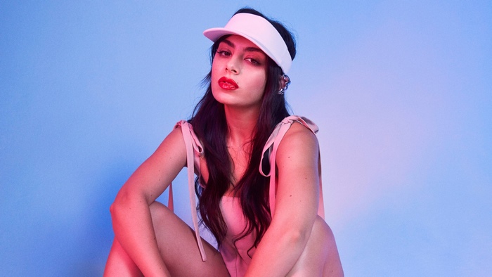 Charli XCX wearing a visor and pink outfit