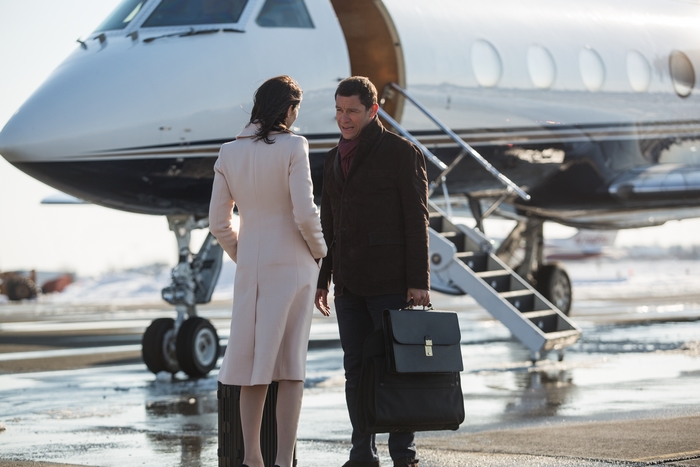 Caitriona Balfe and man with luggage by private jet