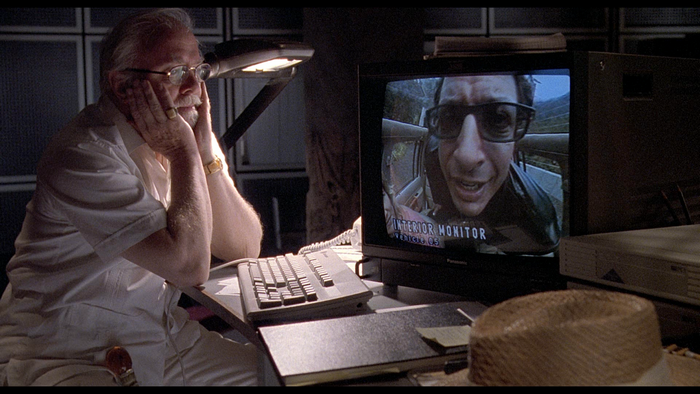 Man watching Jeff Goldblum on monitor