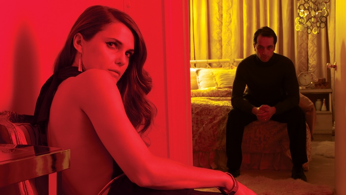 Keri Russell in a red-lit room with a man in the background