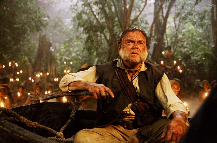 Kevin McNally in a boat with torches