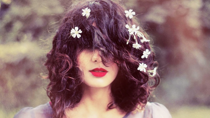 Woman with flowers in her curly hair