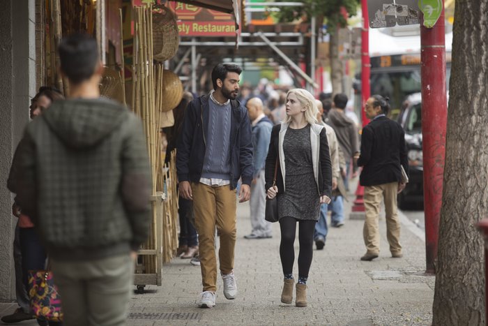 Rahul Kohli and Liv Moore walking on a street