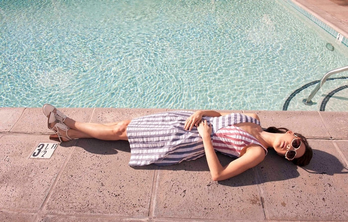 Troian Bellisario lying by a swimming pool