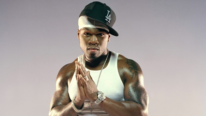 50 Cent wearing a white tank top and LA Dodgers hat