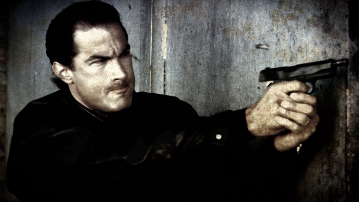Steven Seagal firing a handgun