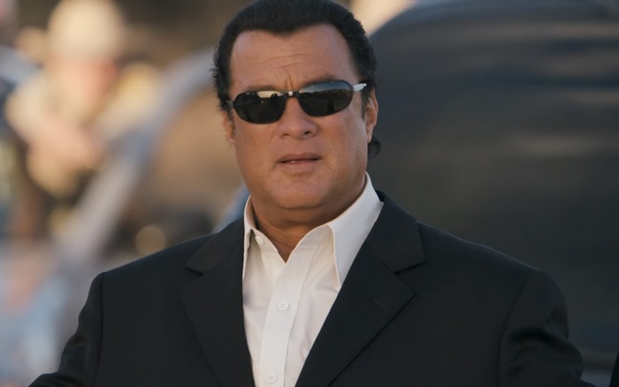 Steven Seagal wearing sunglasses and a suit