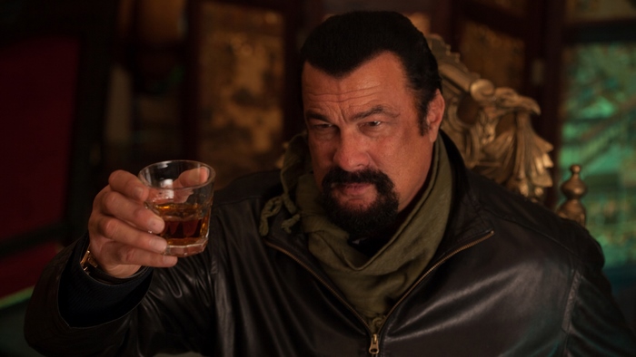 Steven Seagal holding a drink