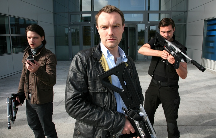 Andrew-Lee Potts with futuristic weapons