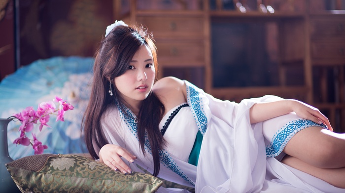 Woman in traditional Chinese dress lying on a couch