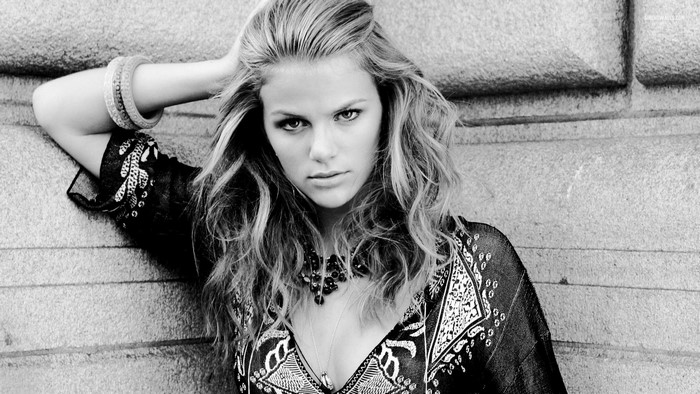 Brooklyn Decker leaning against a stone wall