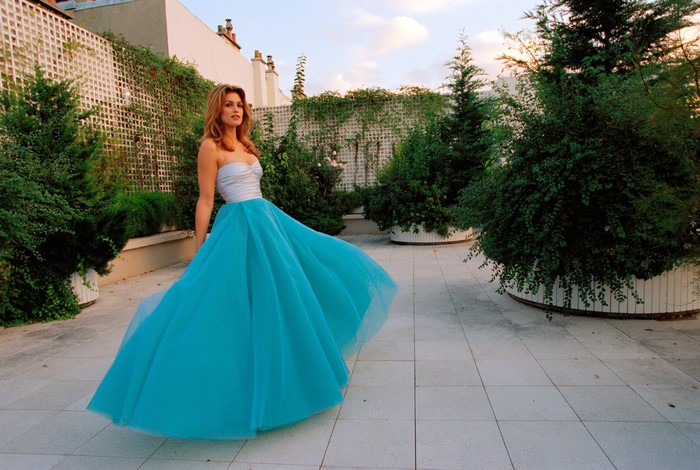 Cindy Crawford in a blue gown on a terrace