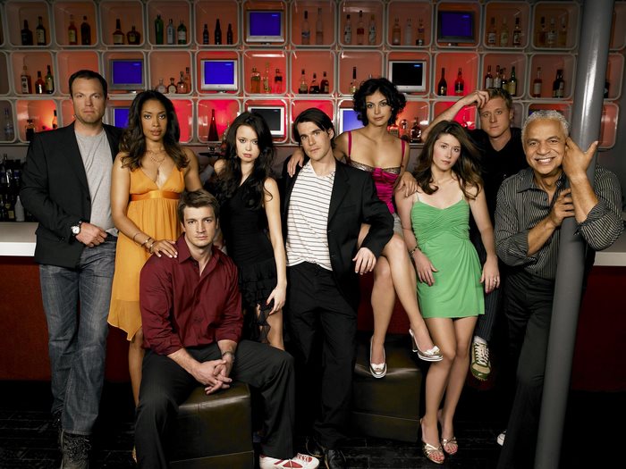 Firefly cast posing in front of a bar