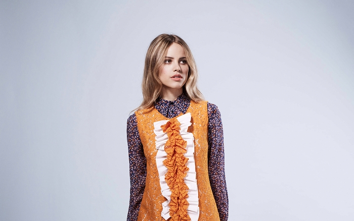 Halston Sage in orange lace dress
