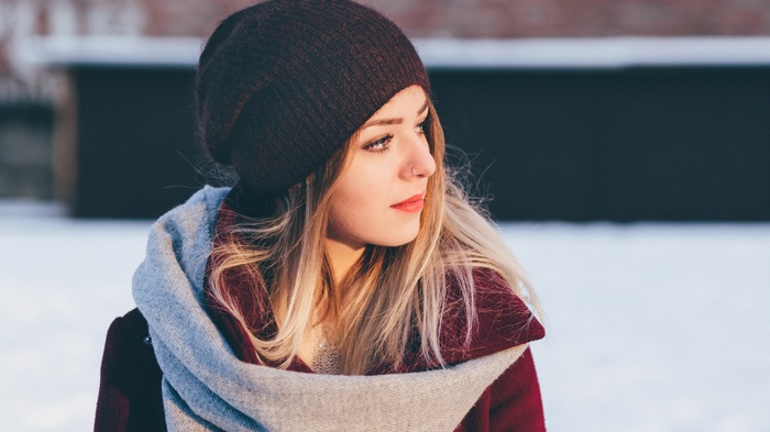 Woman wearing a beanie and scarf in the snow
